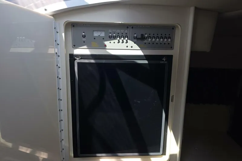 Slide: The Image of Control panel and refrigerator inside a 2002 Formula 330 Sun Sport boat. - 27