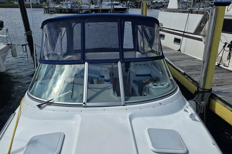 Slide: The Image of 2002 Formula 330 Sun Sport boat docked at marina, featuring blue canopy and sleek design. - 6