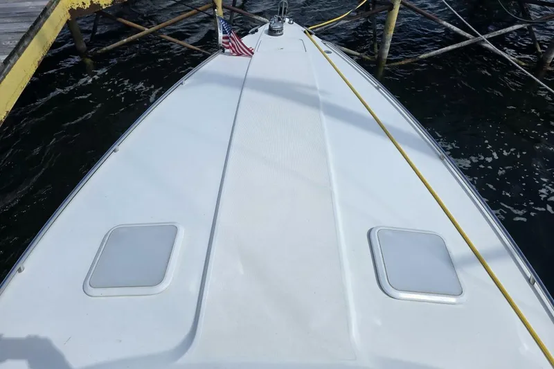 Slide: The Image of 2002 Formula 330 Sun Sport boat docked, featuring a sleek white deck and American flag. - 7