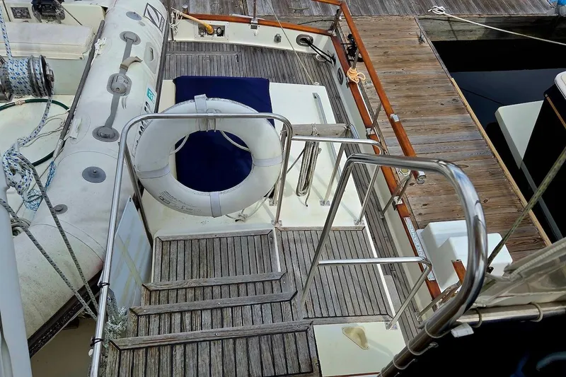 Slide: The Image of 1989 Grand Banks 42 Classic yacht deck with life preserver and wooden flooring. - 14
