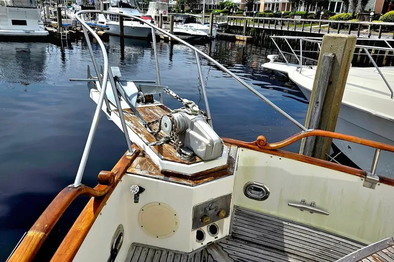 Slide: The Image of 1989 Grand Banks 42 Classic yacht bow with anchor and winch in marina setting. - 15