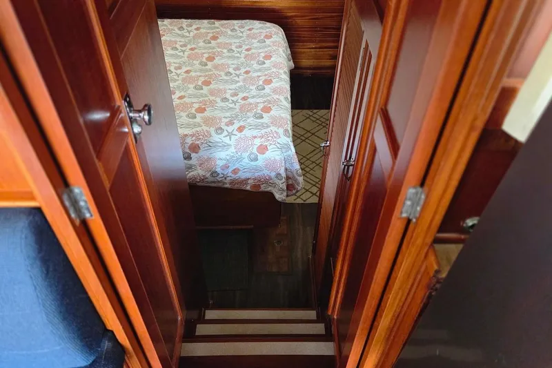 Slide: The Image of Interior of 1989 Grand Banks 42 Classic, featuring wooden doors and a patterned bedspread. - 21