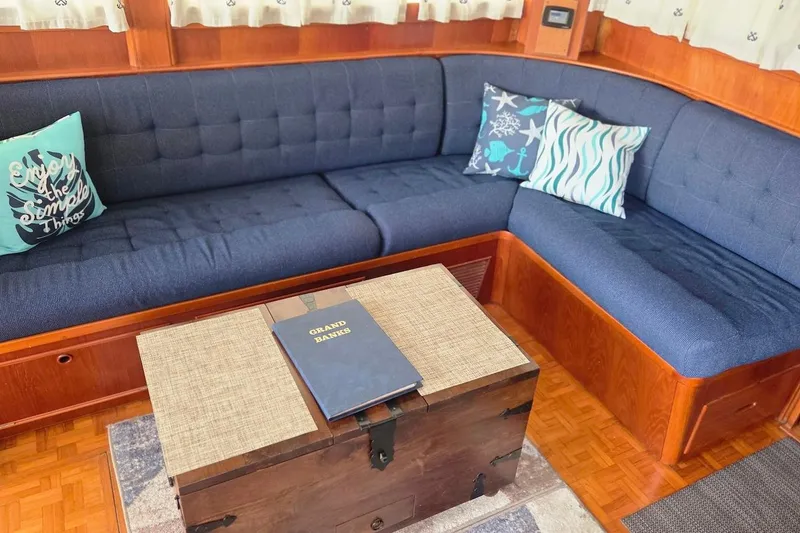 Slide: The Image of Cozy interior of 1989 Grand Banks 42 Classic with blue seating and decorative pillows. - 32