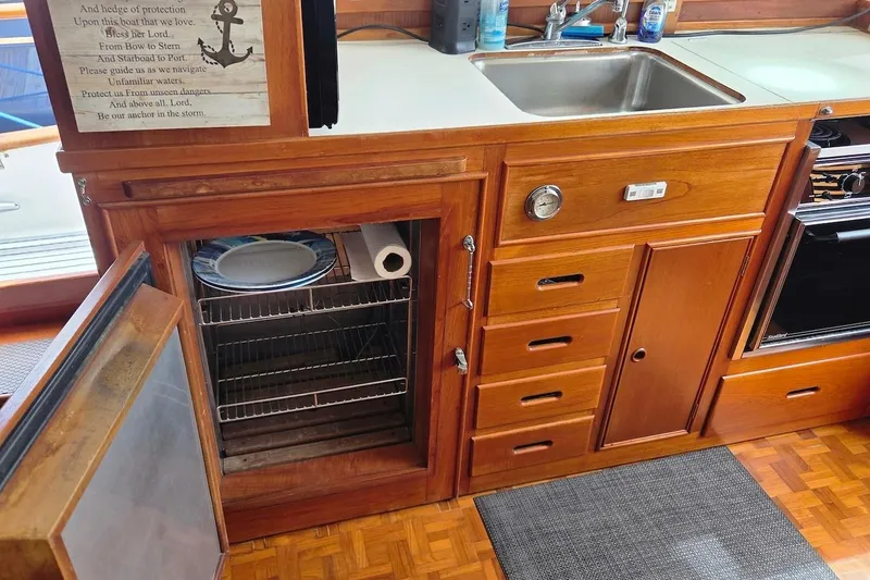 Slide: The Image of 1989 Grand Banks 42 Classic yacht kitchen with wooden cabinetry and stainless steel sink. - 34