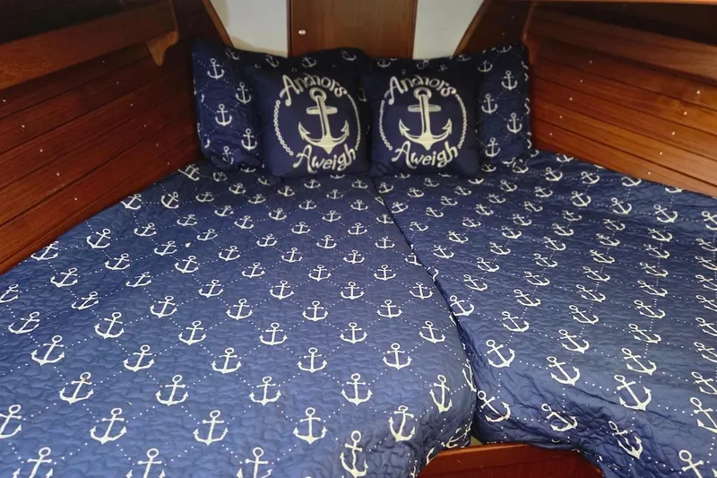 Slide: The Image of Nautical-themed bedding with anchor design in a 1989 Grand Banks 42 Classic cabin. - 42