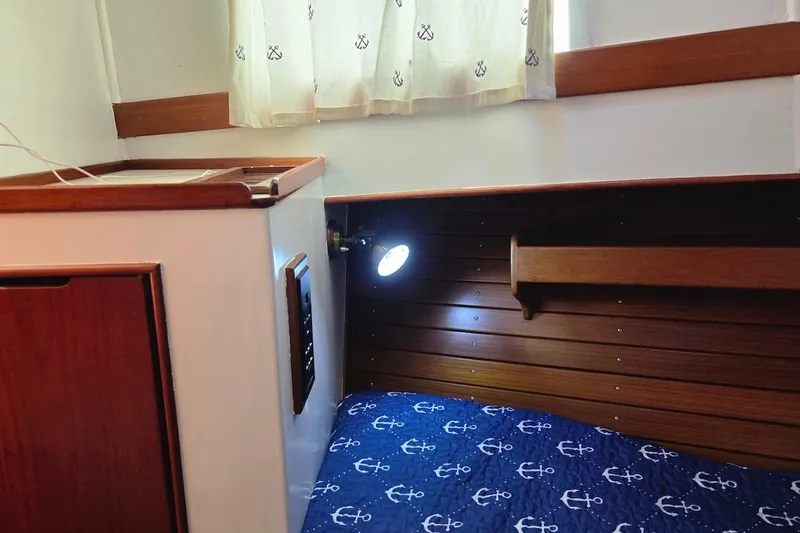 Slide: The Image of Cozy cabin interior of 1989 Grand Banks 42 Classic with nautical-themed bedding. - 44