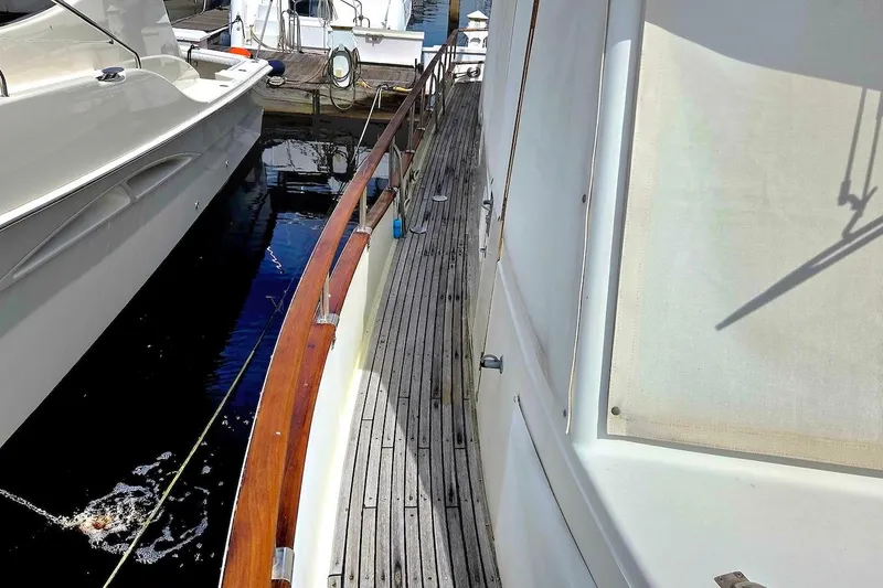 Slide: The Image of 1989 Grand Banks 42 Classic yacht docked, featuring wooden deck and white exterior. - 5