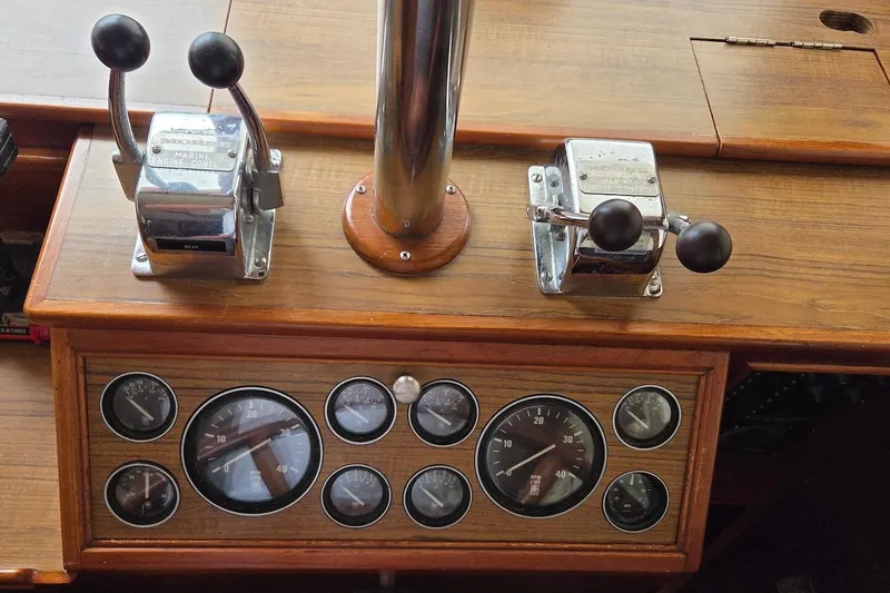 Slide: The Image of Control panel of a 1989 Grand Banks 42 Classic boat with gauges and levers. - 50