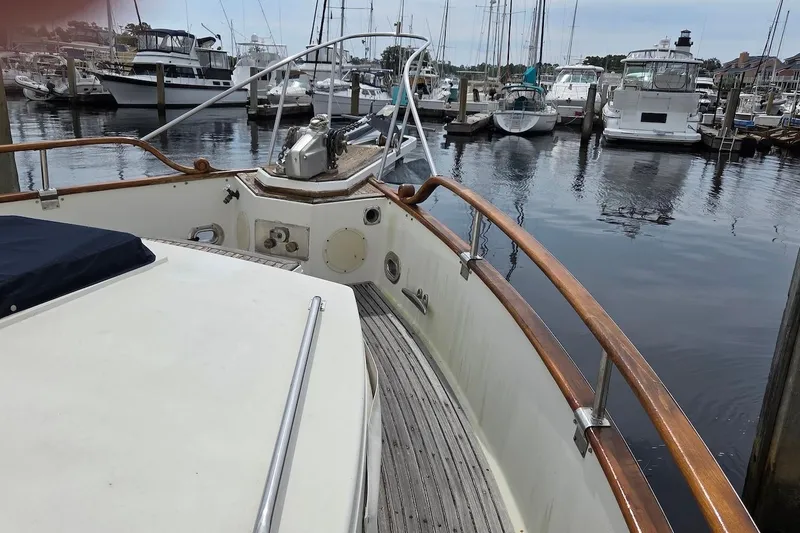 Slide: The Image of 1989 Grand Banks 42 Classic yacht docked in a marina, featuring wooden railings and deck. - 6