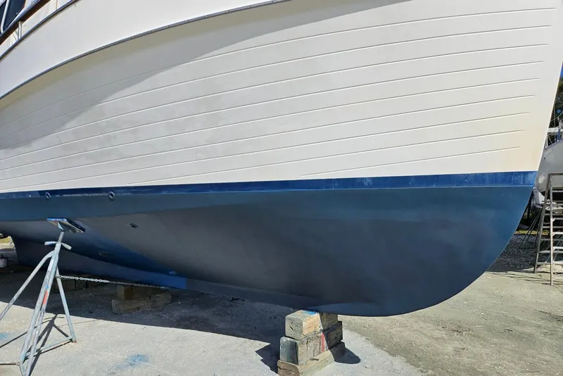 Slide: The Image of 1989 Grand Banks 42 Classic boat hull on dry dock, showcasing blue and white exterior. - 63