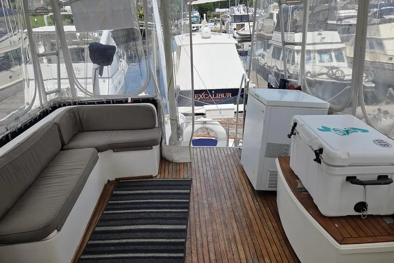 Slide: The Image of 1989 Grand Banks 42 Classic yacht interior with seating, cooler, and marina view. - 7