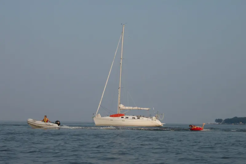 The Image of Sailing yacht Beneteau First 42s7 (1997) on calm waters with small motorboat nearby. - 0