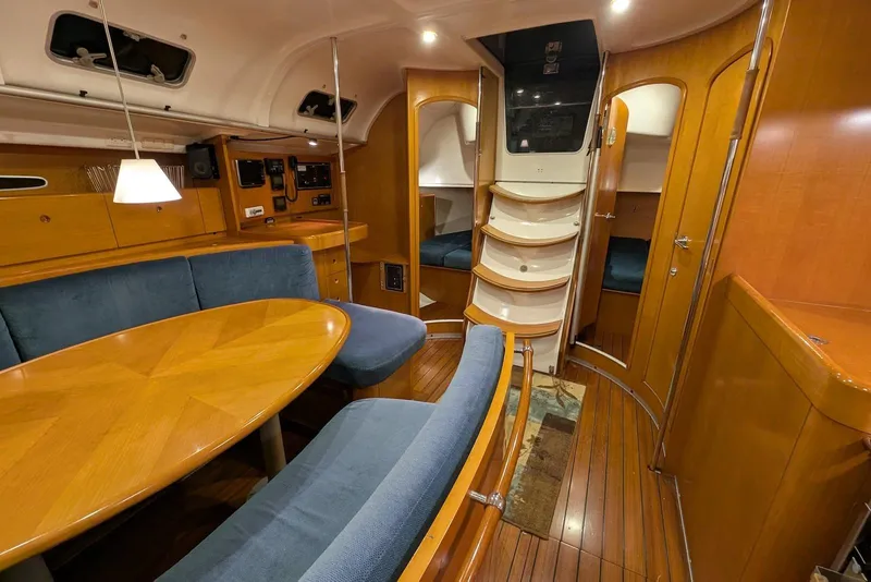 Slide: The Image of Interior of 1997 Beneteau First 42s7 yacht with wood finish and blue seating. - 10