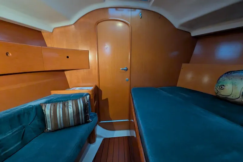 Slide: The Image of Interior cabin of 1997 Beneteau First 42s7 yacht with wood finish and teal seating. - 11