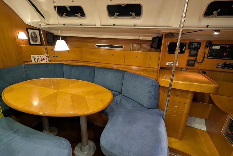 Slide: The Image of Cozy interior of 1997 Beneteau First 42s7 yacht with wooden table and blue seating. - 12