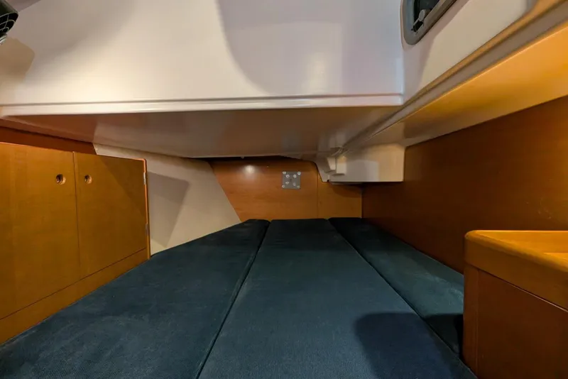 Slide: The Image of Interior cabin of 1997 Beneteau First 42s7 sailboat with wooden cabinetry and blue cushions. - 15