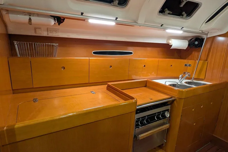 Slide: The Image of 1997 Beneteau First 42s7 yacht kitchen with wooden cabinetry and stainless steel sink. - 18