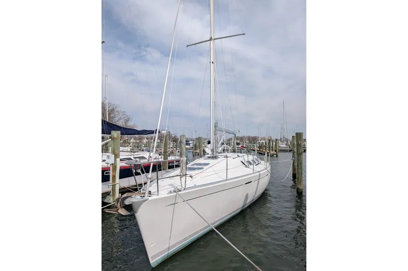 Slide: The Image of 1997 Beneteau First 42s7 sailboat docked at a marina under a cloudy sky. - 4