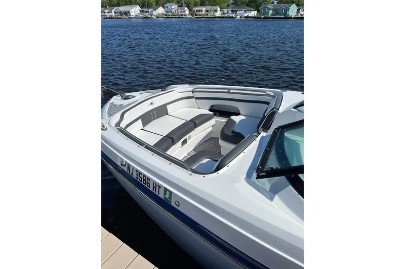 Slide: The Image of 2021 Monterey M6 boat with sleek seating, docked by the water. - 3