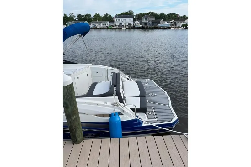 Slide: The Image of 2021 Monterey M6 boat docked by a serene waterfront with houses in the background. - 4