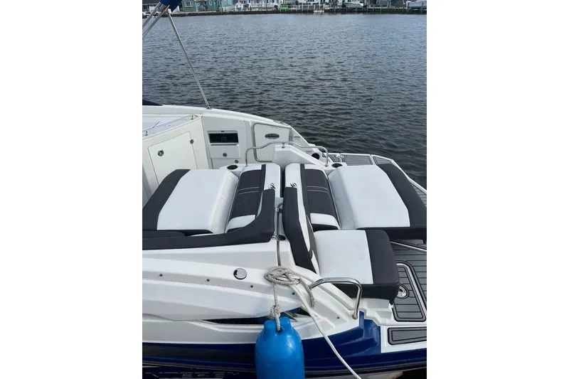 Slide: The Image of 2021 Monterey M6 boat with sleek seating, docked by the water. - 5