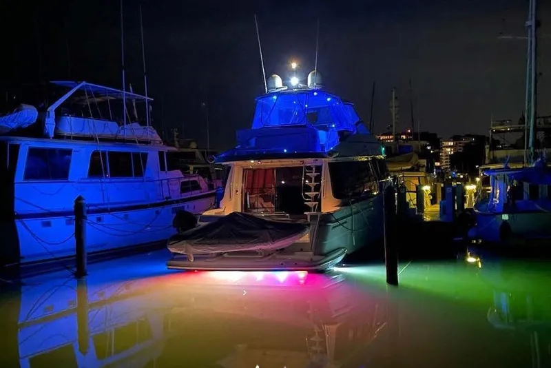 Slide: The Image of Illuminated 2004 Carver 570 Voyager Pilothouse yacht docked at night with colorful lights. - 11