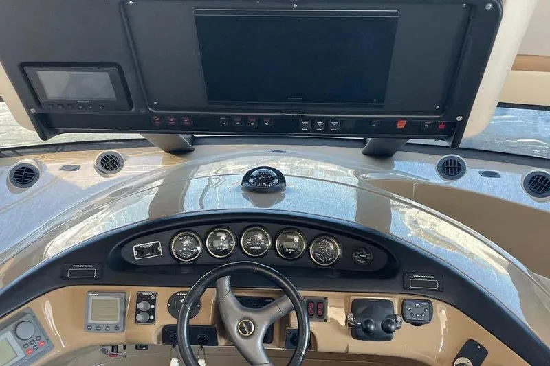 Slide: The Image of Interior view of 2004 Carver 570 Voyager Pilothouse helm with steering wheel and control panels. - 12
