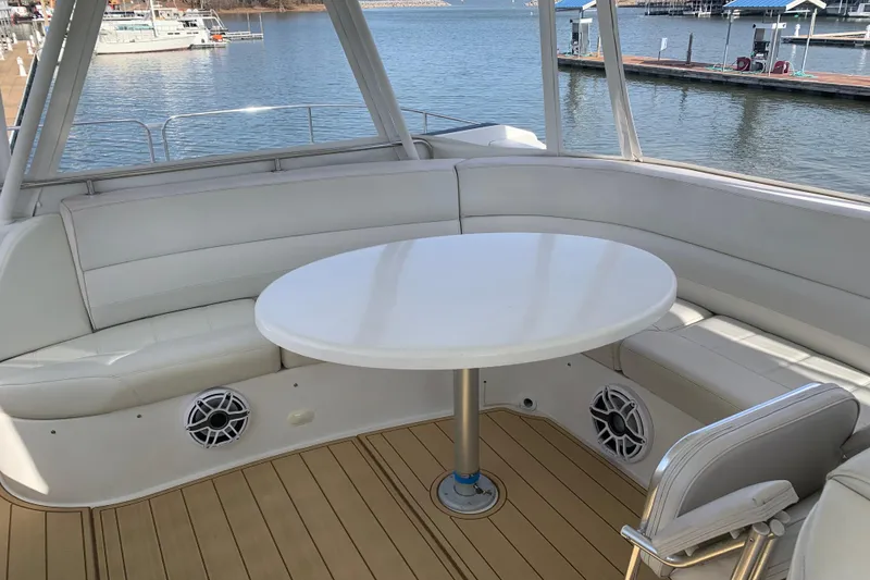 Slide: The Image of 2004 Carver 570 Voyager Pilothouse yacht interior with round table and white seating. - 38