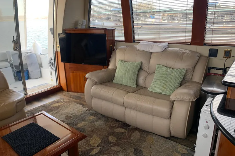 Slide: The Image of Interior of 2004 Carver 570 Voyager Pilothouse with beige sofa and TV. - 41