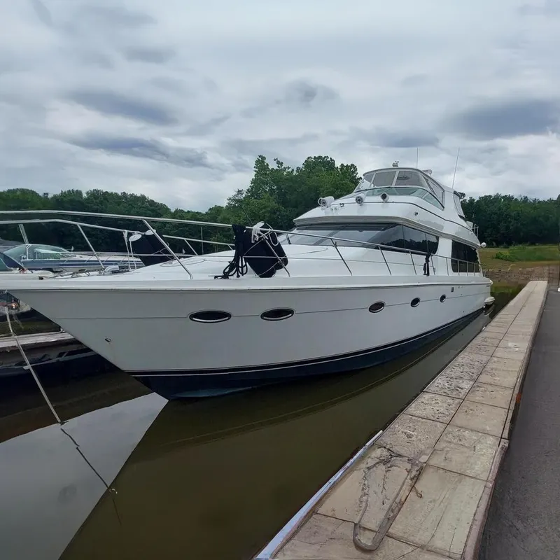 The Image of 2004 Carver 570 Voyager Pilothouse yacht docked on a cloudy day. - 0
