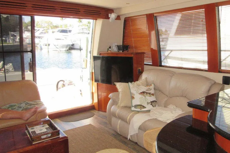 Slide: The Image of Luxurious interior of 2004 Carver 570 Voyager Pilothouse yacht with comfortable seating and marina view. - 18