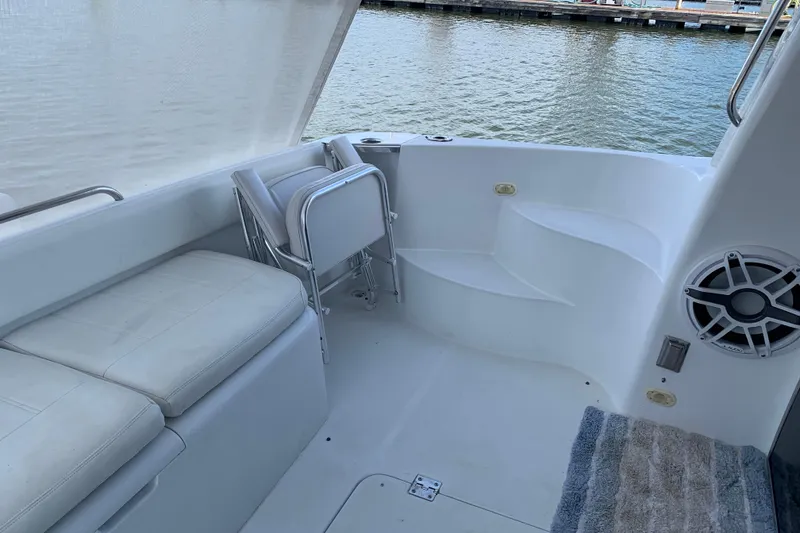 Slide: The Image of 2004 Carver 570 Voyager Pilothouse boat interior with seating and steps by the water. - 34