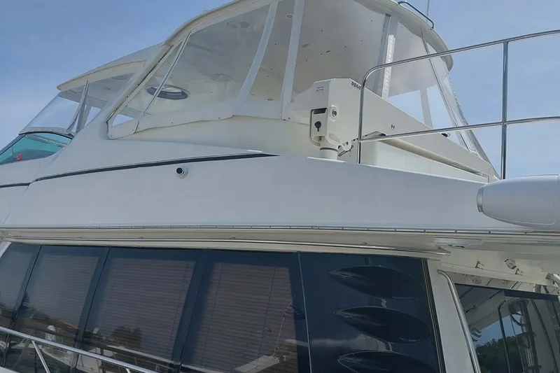 Slide: The Image of 2004 Carver 570 Voyager Pilothouse yacht, showcasing upper deck and windows. - 4
