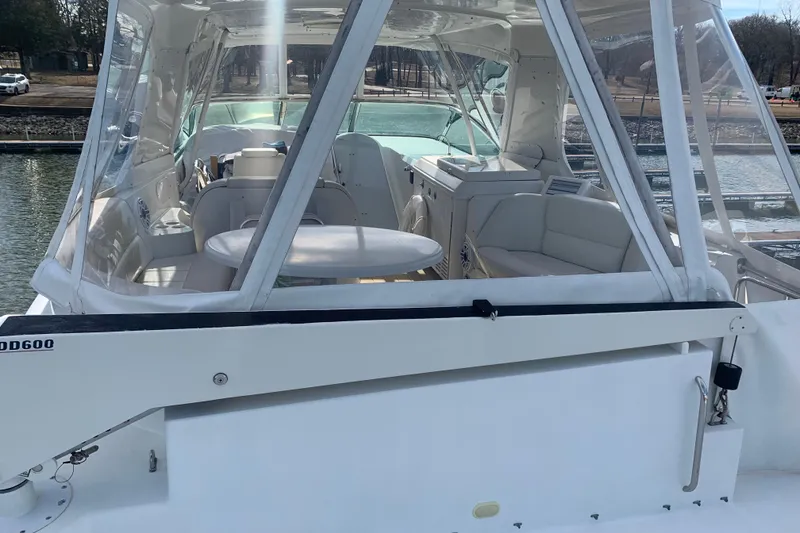 Slide: The Image of 2004 Carver 570 Voyager Pilothouse yacht interior with seating and table, docked by the water. - 40