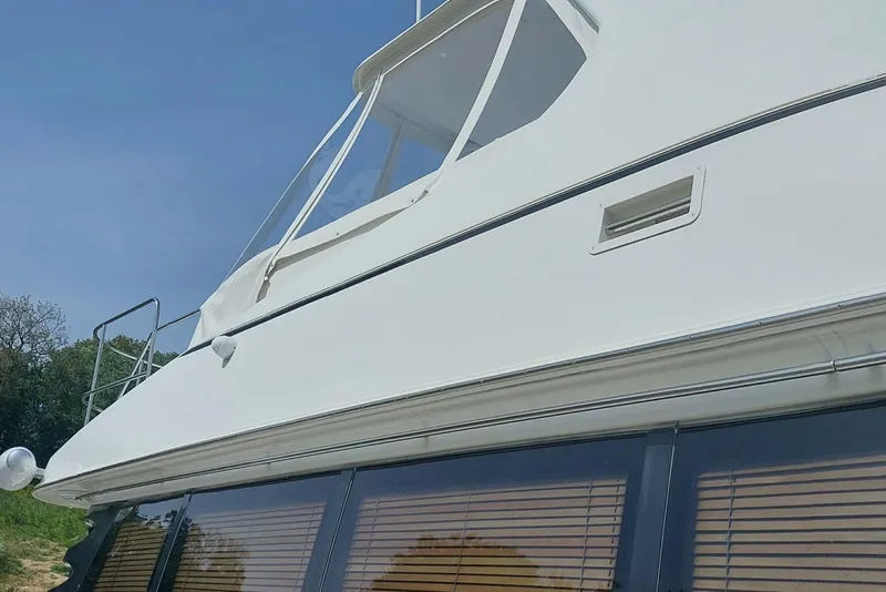 Slide: The Image of 2004 Carver 570 Voyager Pilothouse yacht, side view with windows and railing. - 5