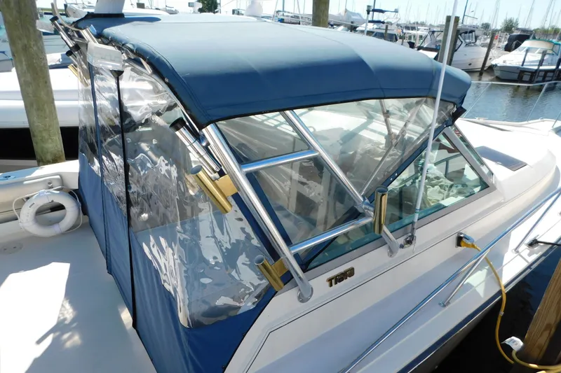 Slide: The Image of 1993 Tiara Yachts 3100 Open with blue canopy docked at marina. - 10