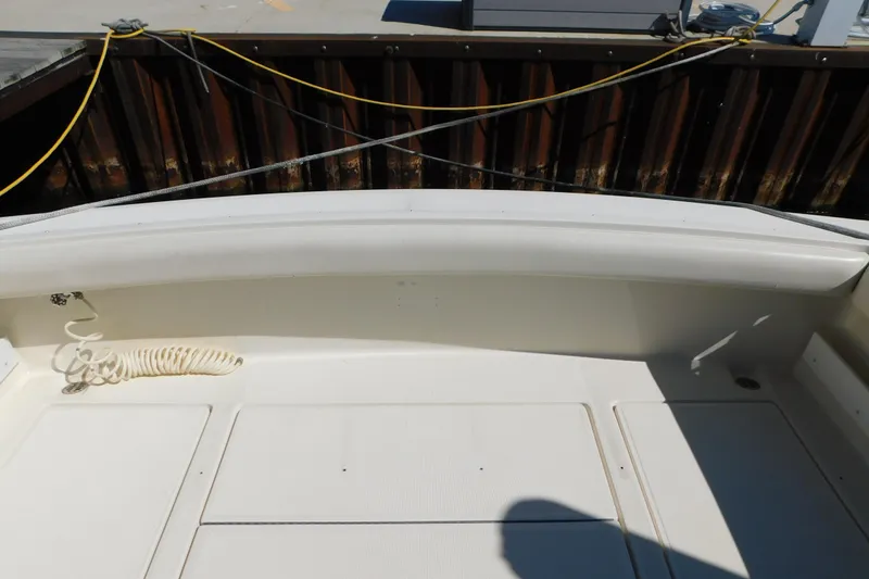 Slide: The Image of 1993 Tiara Yachts 3100 Open boat deck with coiled rope and dock background. - 13