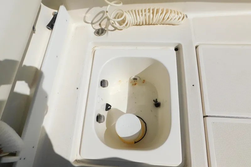 Slide: The Image of 1993 Tiara Yachts 3100 Open deck with storage compartment and coiled hose. - 15