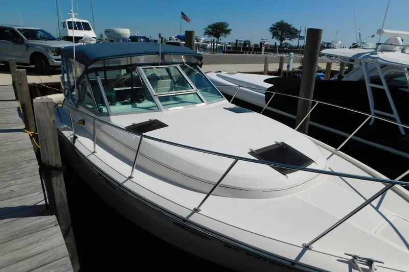 Slide: The Image of 1993 Tiara Yachts 3100 Open docked at marina, featuring sleek design and spacious deck. - 3