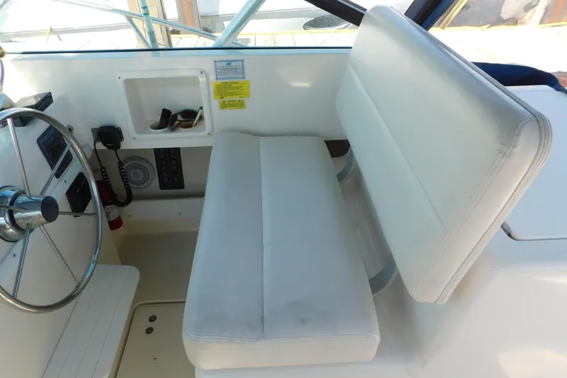 Slide: The Image of 1993 Tiara Yachts 3100 Open helm with white seating and steering wheel. - 31