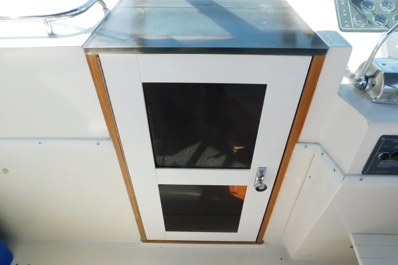 Slide: The Image of 1993 Tiara Yachts 3100 Open cabin door with wood trim and metal handle. - 47