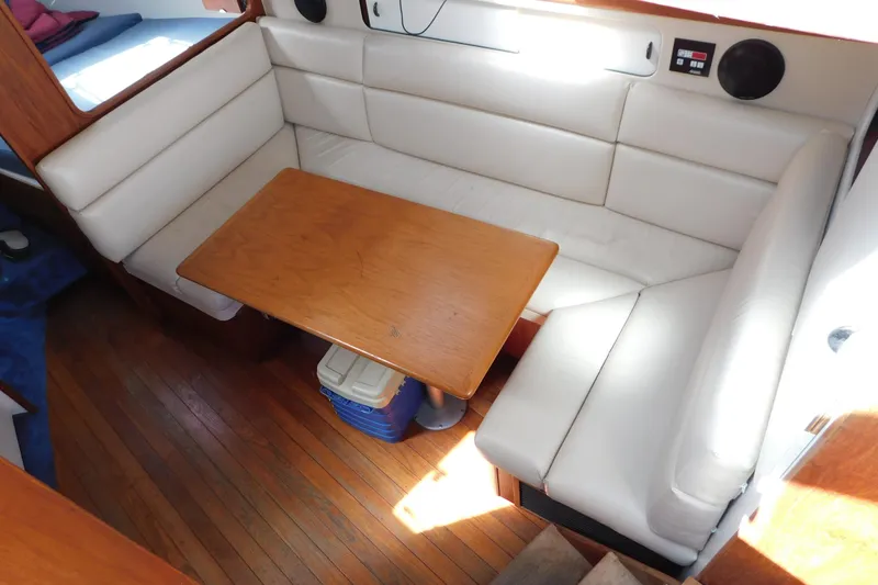 Slide: The Image of Interior of 1993 Tiara Yachts 3100 Open with white seating and wooden table. - 52