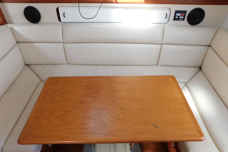 Slide: The Image of Interior of 1993 Tiara Yachts 3100 Open with wooden table and white cushioned seating. - 53