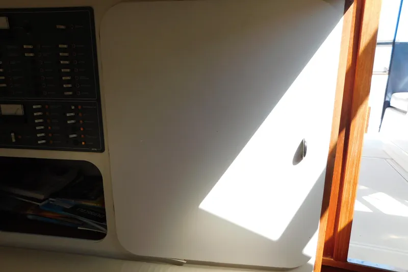 Slide: The Image of Interior view of a 1993 Tiara Yachts 3100 Open, featuring control panel and storage. - 58