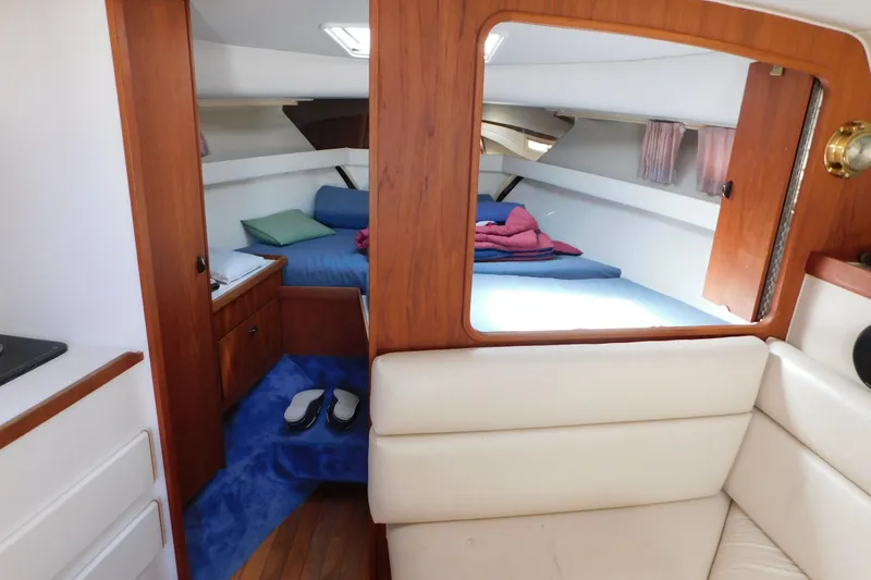 Slide: The Image of Interior of 1993 Tiara Yachts 3100 Open, featuring cozy cabin with bed and wooden accents. - 62