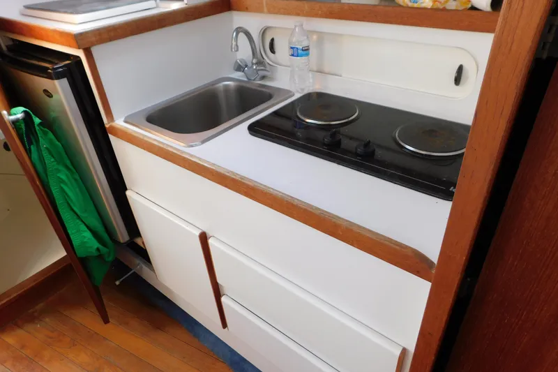 Slide: The Image of Compact kitchen in a 1993 Tiara Yachts 3100 Open, featuring a sink and stovetop. - 69