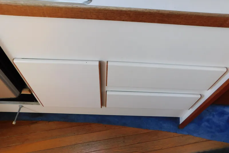 Slide: The Image of Interior cabinetry of a 1993 Tiara Yachts 3100 Open, featuring white panels and wood accents. - 72