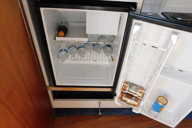 Slide: The Image of Mini fridge on 1993 Tiara Yachts 3100 Open, stocked with drinks and canned goods. - 76