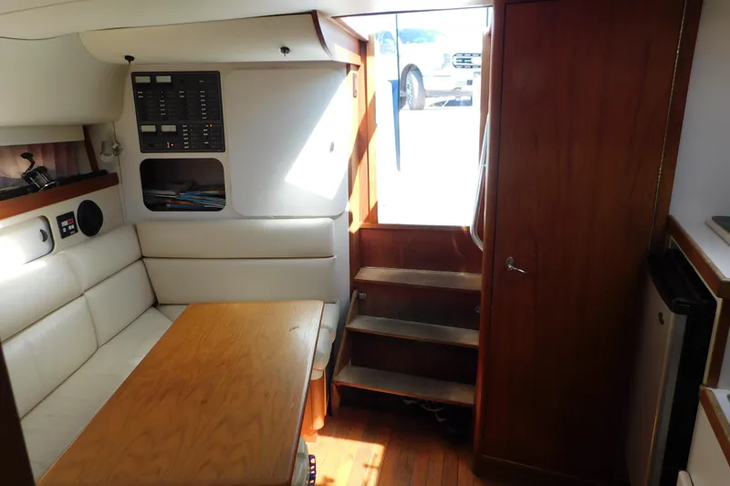 Slide: The Image of 1993 Tiara Yachts 3100 Open cabin interior with seating, table, and stairs. - 78
