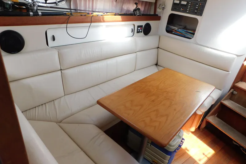 Slide: The Image of 1993 Tiara Yachts 3100 Open interior with white seating and wooden table. - 79